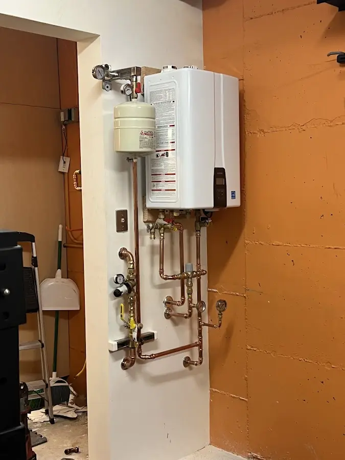 Plumbing technician inspecting water heater connections in York